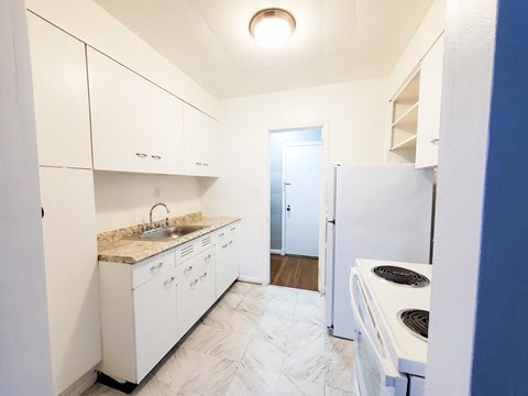 a renovated kitchen with white appliances and white cabinets