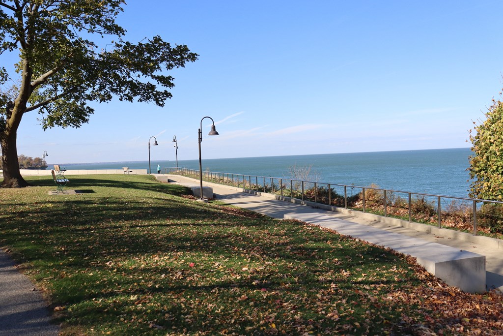 a sidewalk next to the ocean on a sunny day