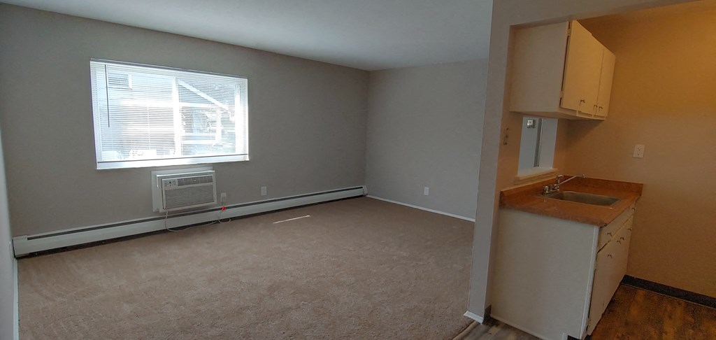 an empty room with a sink and a window