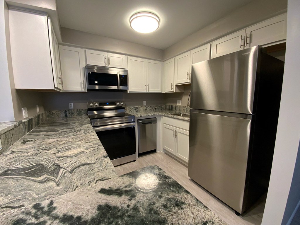 a kitchen with stainless steel appliances and marble counter tops