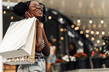 a woman holding several shopping bags and laughing