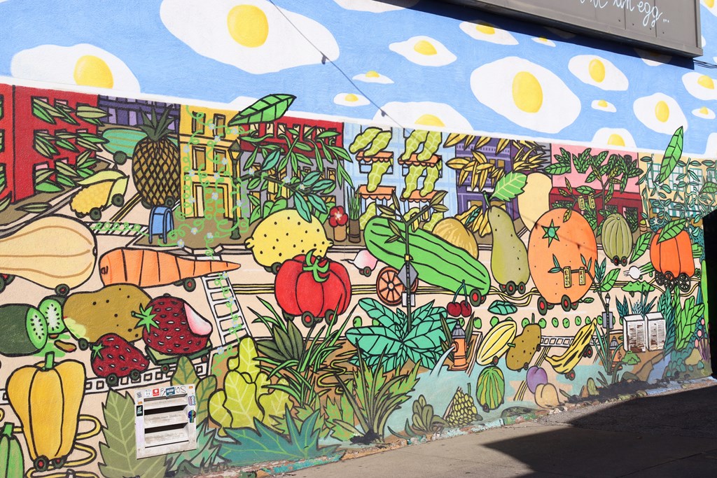 a mural of fruits and vegetables on the side of a building