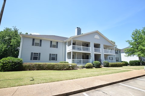 A two-story apartment building with a balcony on the second floor.