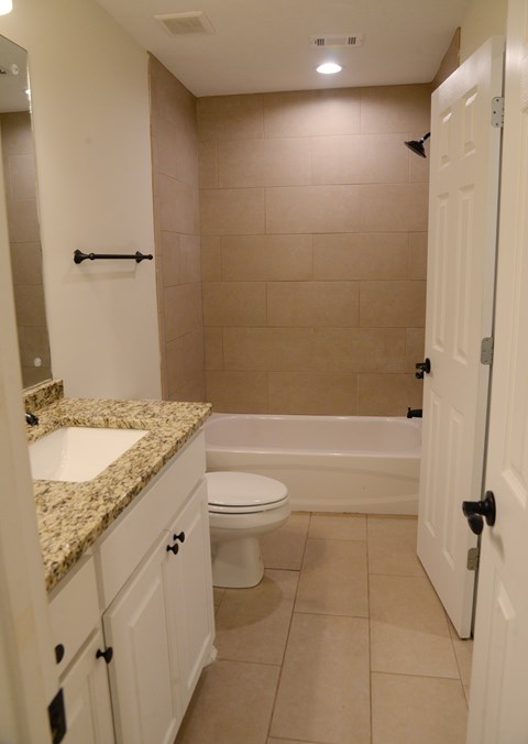 A bathroom with a toilet, sink, and bathtub.