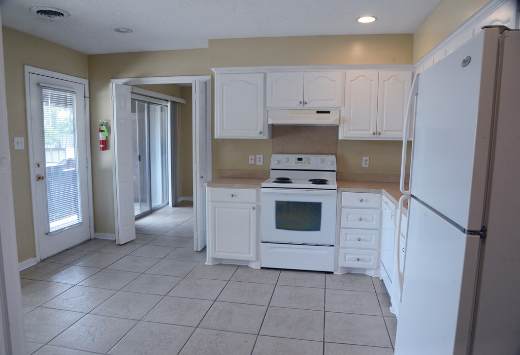 A kitchen with white appliances and cabinets.
