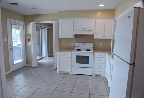 A kitchen with white appliances and cabinets.