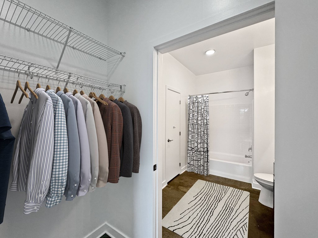 A white bathroom with a white toilet and a white shower curtain.