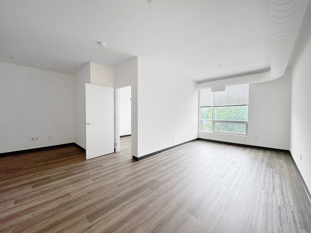 A room with wooden flooring and white walls.
