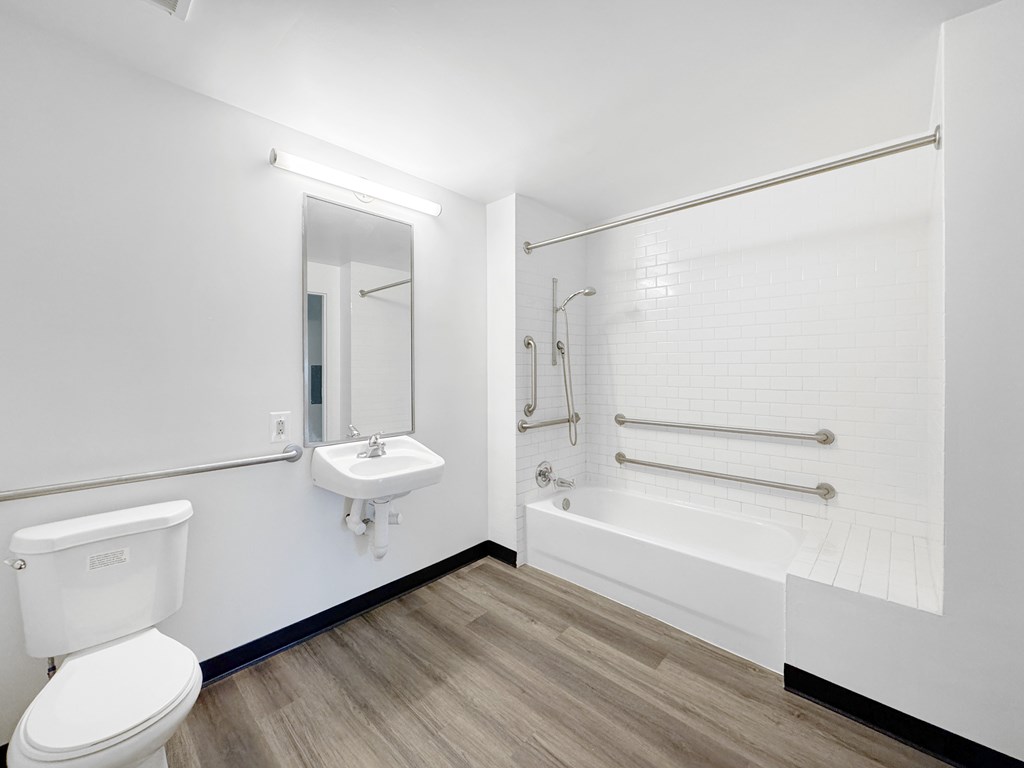A white bathroom with a toilet, sink, and bathtub.
