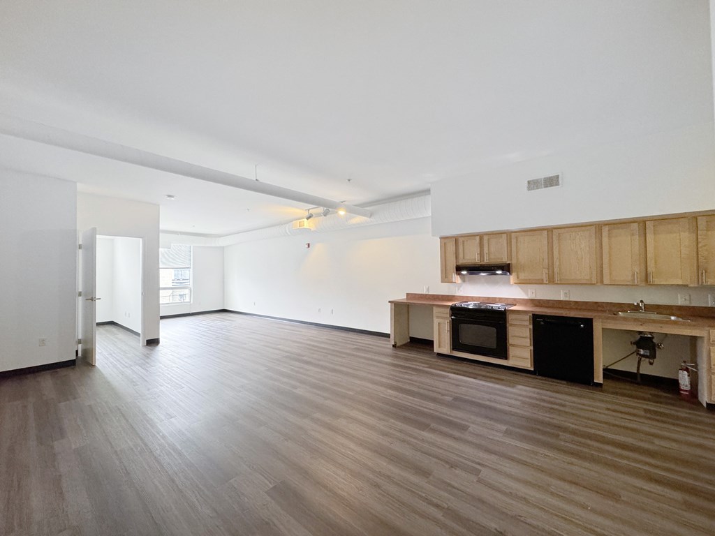 A kitchen area with a wooden floor and a counter.