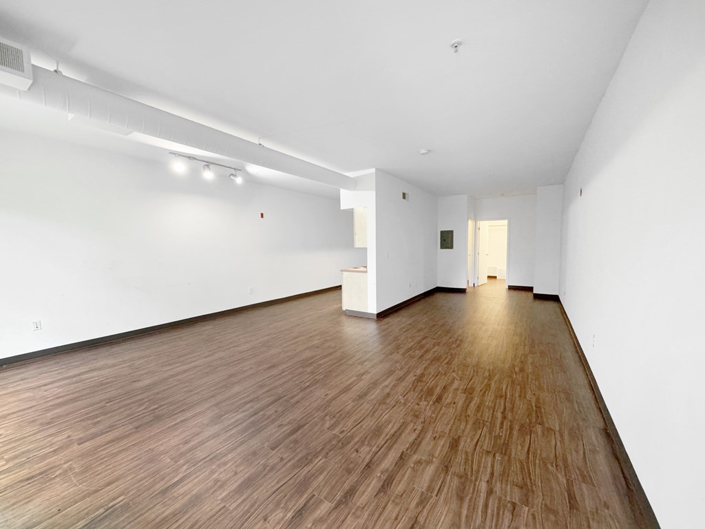 A room with wooden flooring and white walls.