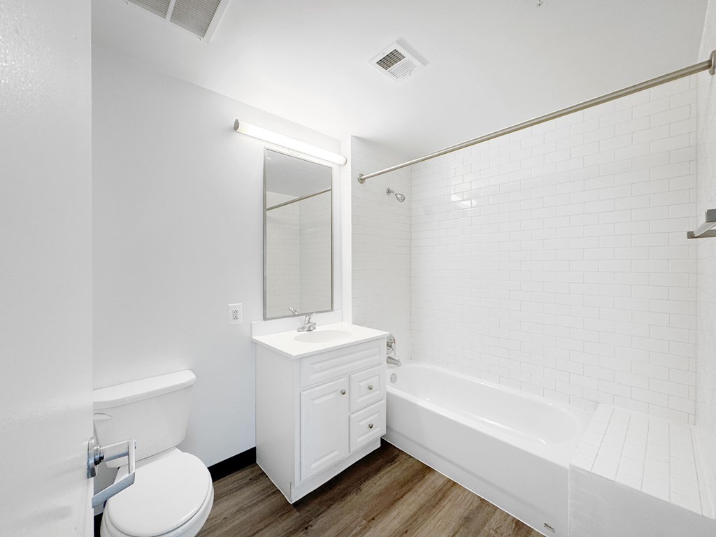 A white bathroom with a toilet, sink, and bathtub.