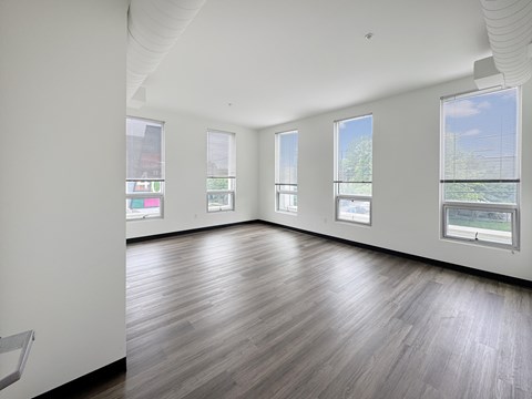 A large empty room with wooden floors and white walls.