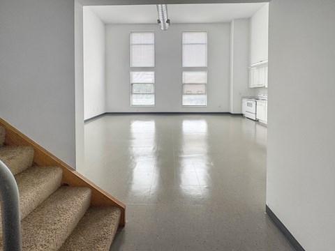A white room with a staircase leading to the second floor.