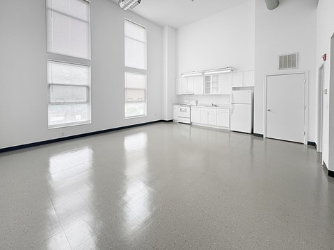 A white kitchen with a refrigerator and cabinets.