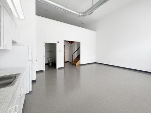 A kitchen with white cabinets and a white fridge.