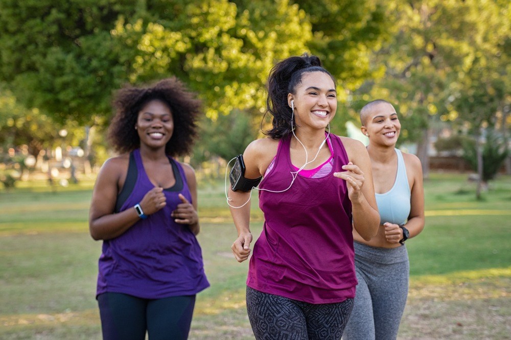Three women jogging in a park.