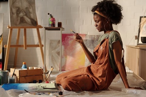 A woman artist painting in a studio.