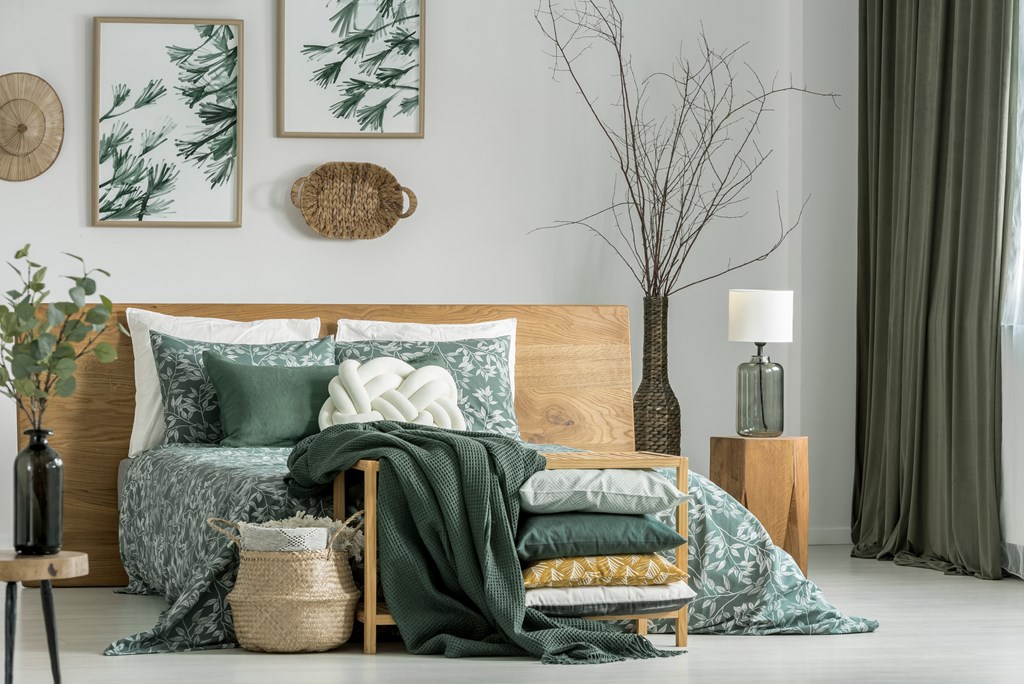 A bedroom with a bed, pillows, blankets, and decorative items.