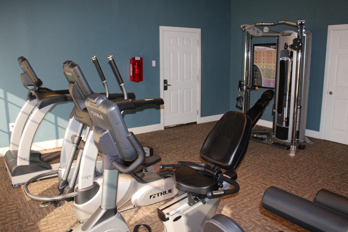 This is a photo of the fitness center showing workout machines at Woodbridge Apartments in Dallas, TX.