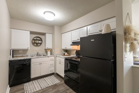 a kitchen with black appliances and white cabinets