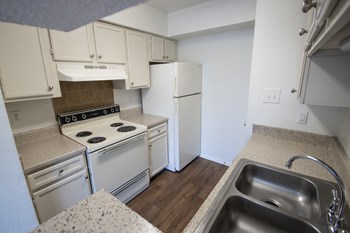 This is a photo of the kitchen in a 1024 square foot 3 bedroom apartment at The Boulders Apartments in Garland, TX.