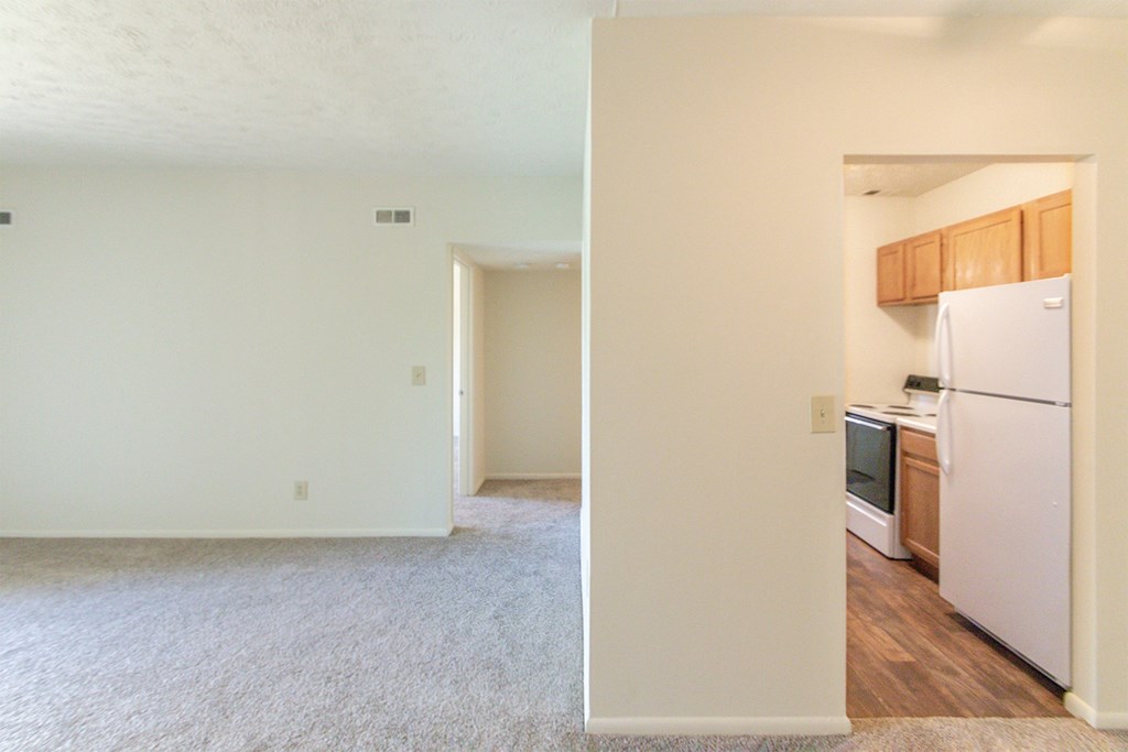 This is a photo of the living room and kitchen from the dining room in the 652 square foot, 1 bedroom, 1 bath A-style apartment at Blue Grass Manor Apartments in Erlanger, KY.