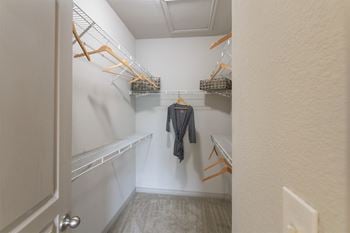 This is a photo of the bedroom walk-in closet in the 826 square foot 1 bedroom , 1 bath apartment at The Brownstones Townhome Apartments in Dallas, TX.