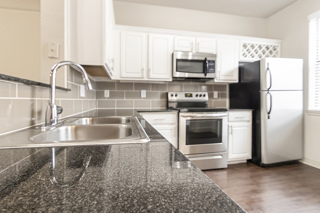 This is a picture of the kitchen of the 1320 square foot 2 bedroom, 2 and 1/2 bath floor plan at The Brownstones Townhome Apartments in Dallas, TX..