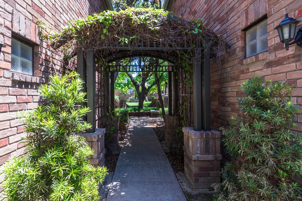This is a photo of the the entrance to the courtyard at The Brownstones Townhome Apartments in Dallas, TX.
