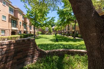 This is a photo of the building exteriors/the courtyard at The Brownstones Townhome Apartments in Dallas, TX.