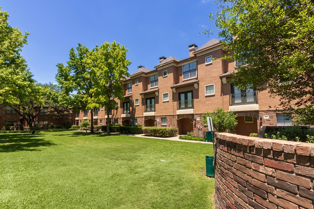 This is a photo of the building exteriors/the courtyard at The Brownstones Townhome Apartments in Dallas, TX.