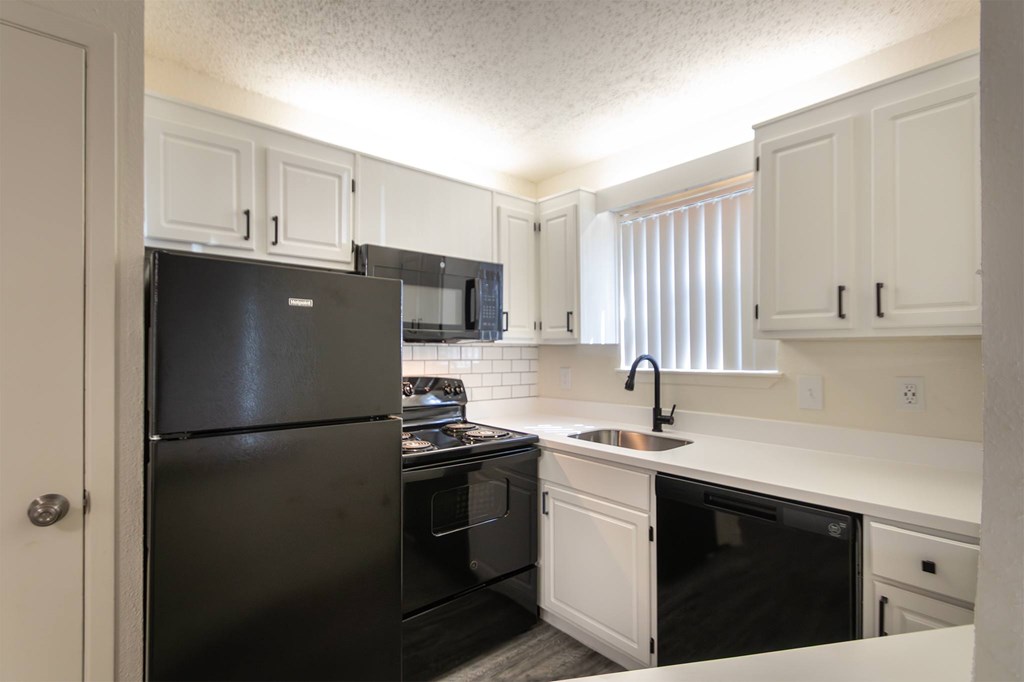 This is a photo of the kitchen in an upgraded 450 square foot efficiency apartment at Cambridge Court Apartments in Dallas, TX.