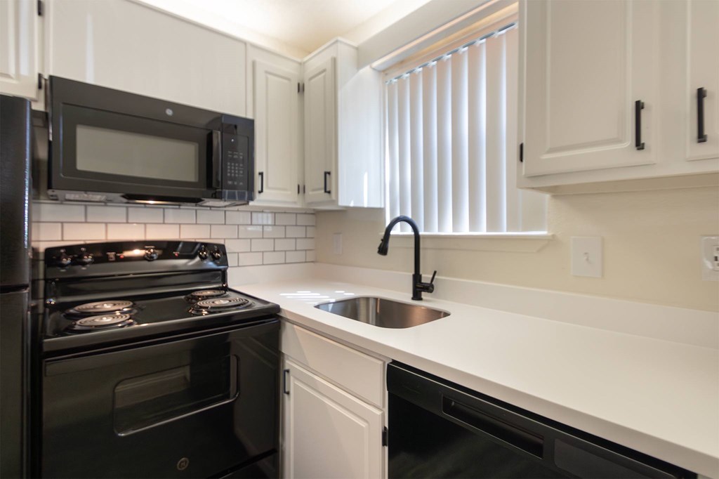 This is a photo of the kitchen in an upgraded 450 square foot efficiency apartment at Cambridge Court Apartments in Dallas, TX.