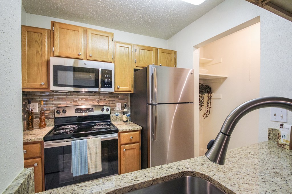 This is a photo of the kitchen in the 692 square foot 1 bedroom model apartment at Cambridge Court Apartments in Dallas, TX.