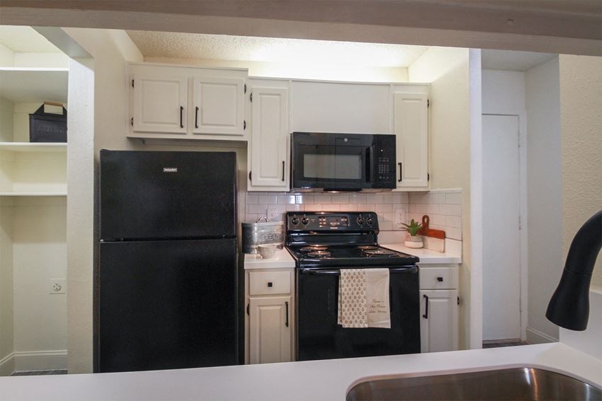 Photo of the kitchen in a 692 square foot 1 bed, 1 bath model aprtment at Cambridge Court Apartments in Dallas Texas - Photo Gallery