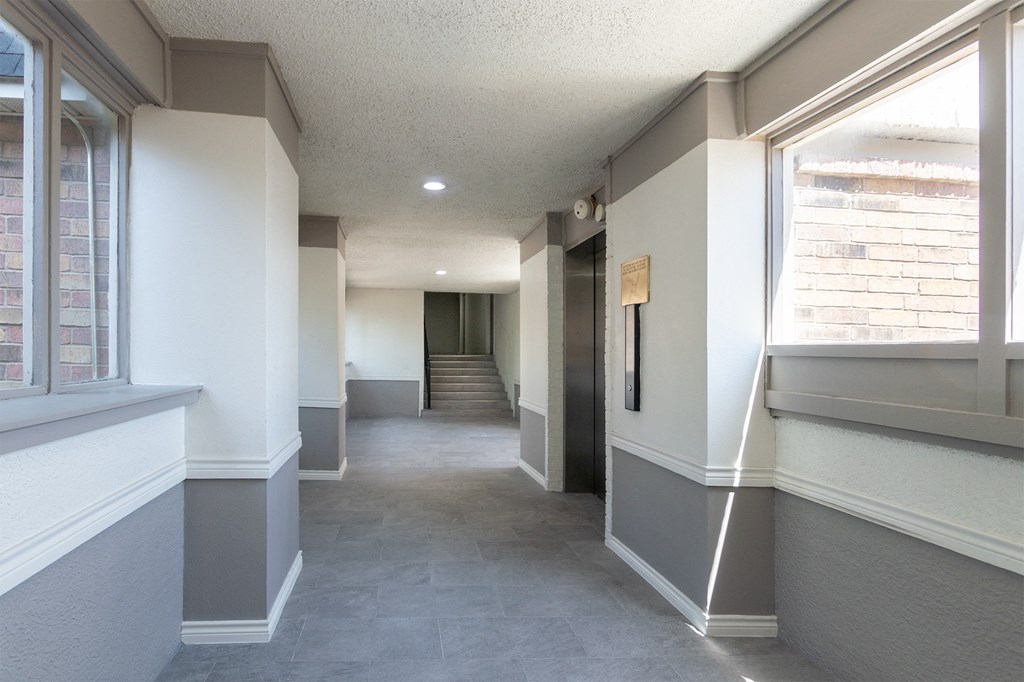 This is a photo of an elevatorin an open air hallway with new tile in the 450 square foot efficiency apartment at Cambridge Court Apartments in Dallas, TX.