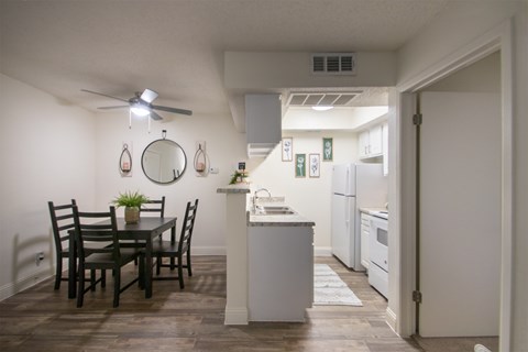 A kitchen with a dining table and chairs.