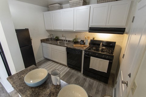 a kitchen with black appliances and white cabinets