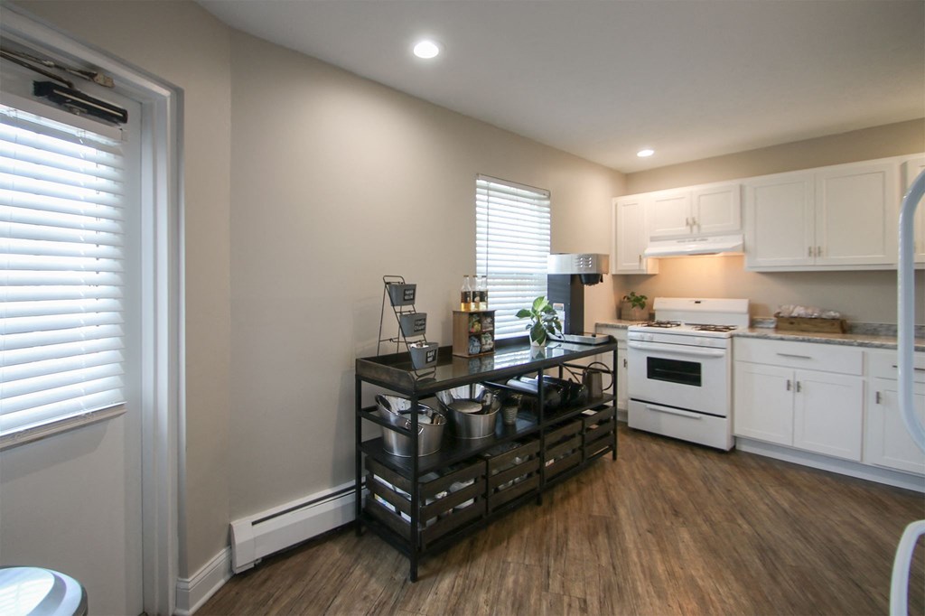 a kitchen with white appliances and a black counter top