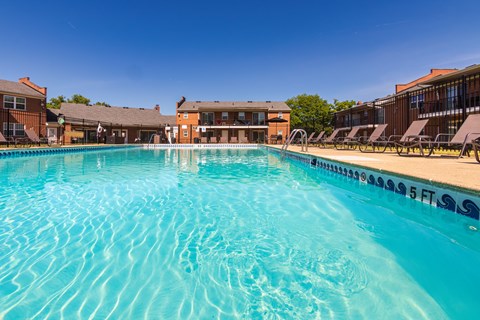 inviting swimming pool and lounge chairs at Compton Lake Apartments on a sunny day
