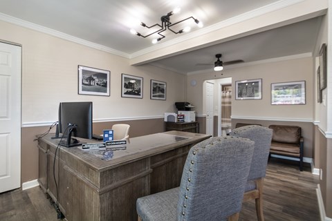 Leasing desk and waiting area at Colonial Ridge Apartments in Cincinnati, with visitor chairs, wall art, office seating, and soft neutral finishes.