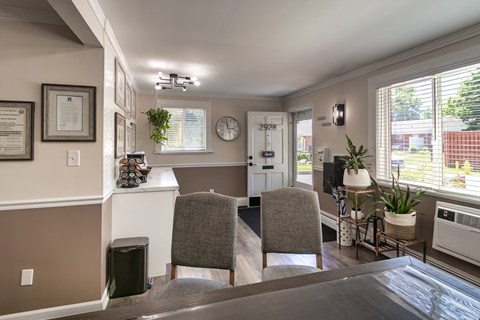 Colonial Ridge leasing office view with guest seating, plants, natural light from the window, and a warm office-style layout.