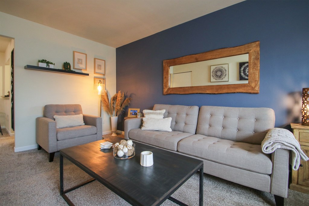 This is a photo of the living room of the 550 square foot 1 bedroom, 1 bath, balcony floor plan model apartment at College Woods Apartments in Cincinnati, OH.