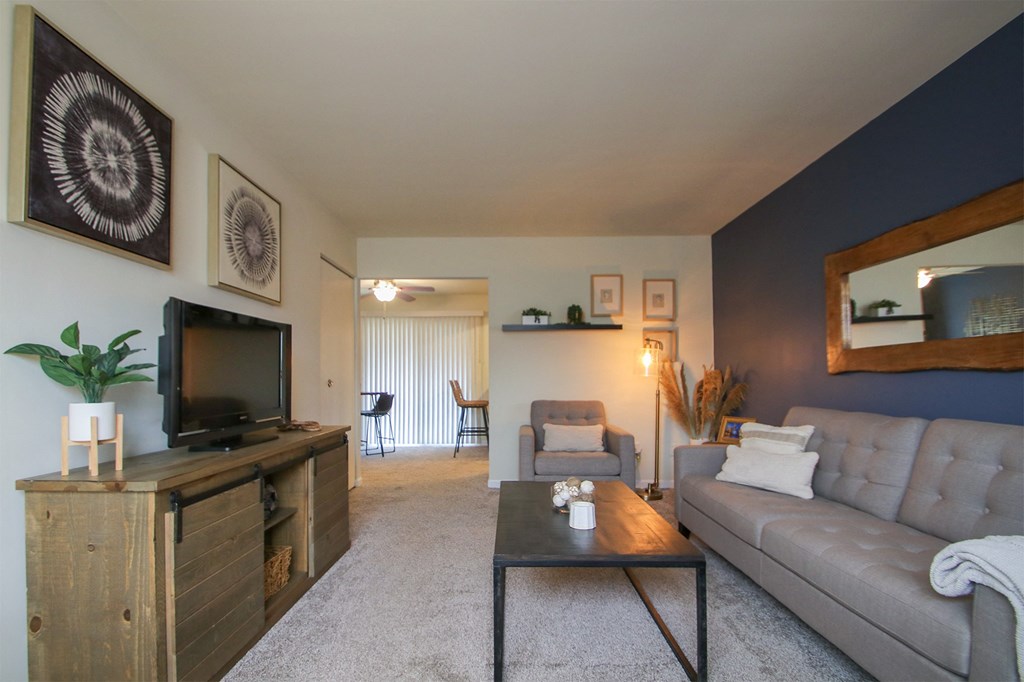 This is a photo of the living room of the 550 square foot 1 bedroom, 1 bath, balcony floor plan model apartment at College Woods Apartments in Cincinnati, OH.