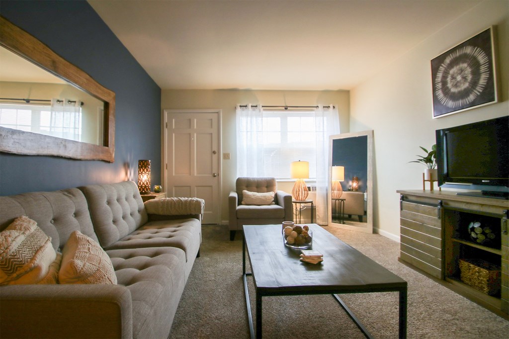 This is a photo of the living room room of the 550 square foot 1 bedroom, 1 bath, balcony floor plan model apartment at College Woods Apartments in Cincinnati, OH.