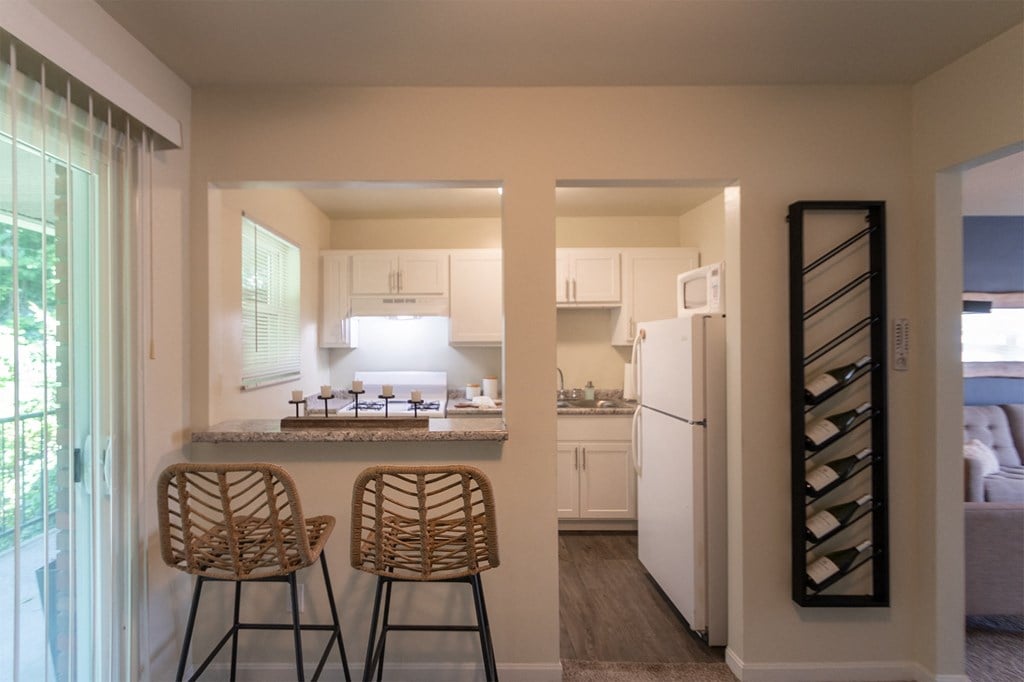 This is a photo of the kitchen with pass through breakfast bar of the 550 square foot 1 bedroom, 1 bath, balcony floor plan model apartment at College Woods Apartments in thne NOrth College Hill neighborhood of Cincinnati, OH.
