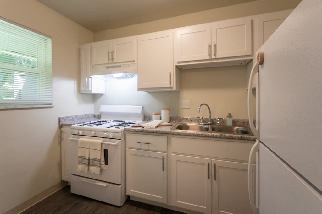 This is a photo of the kitchen with pass through breakfast bar of the 550 square foot 1 bedroom, 1 bath, balcony floor plan model apartment at College Woods Apartments in thne NOrth College Hill neighborhood of Cincinnati, OH.