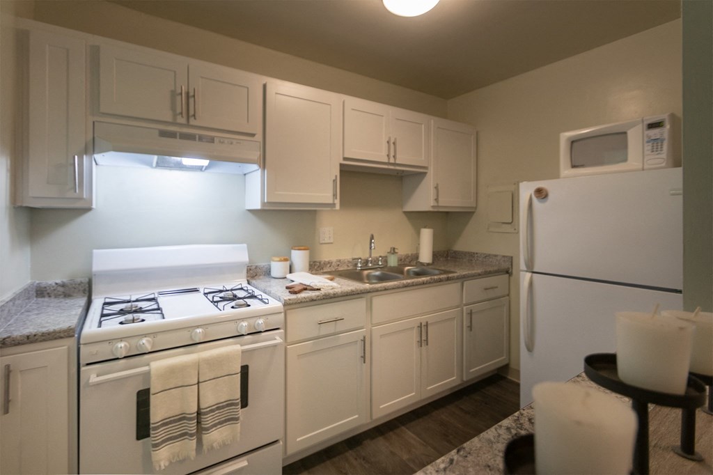This is a photo of the kitchen with pass through breakfast bar of the 550 square foot 1 bedroom, 1 bath, balcony floor plan model apartment at College Woods Apartments in thne NOrth College Hill neighborhood of Cincinnati, OH.