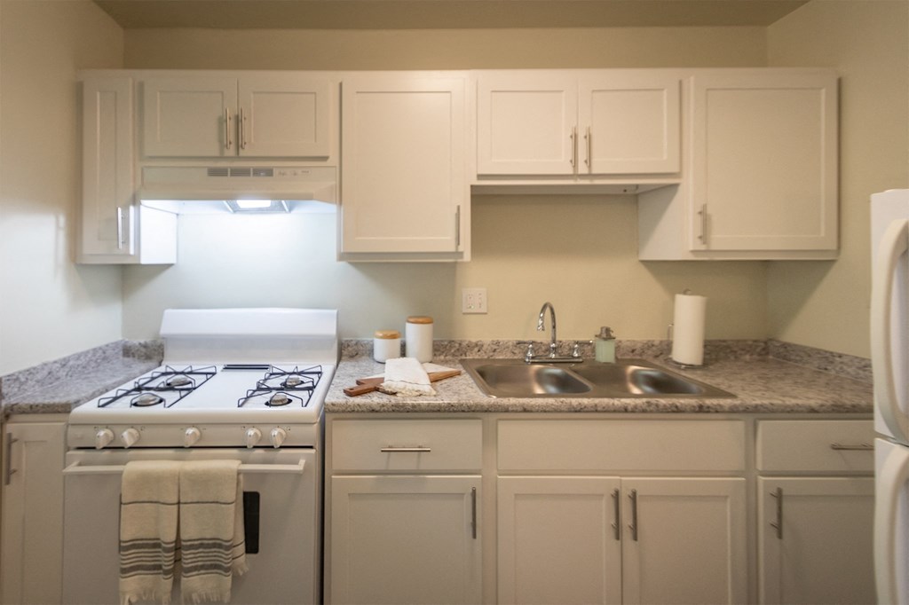 This is a photo of the kitchen with pass through breakfast bar of the 550 square foot 1 bedroom, 1 bath, balcony floor plan model apartment at College Woods Apartments in thne NOrth College Hill neighborhood of Cincinnati, OH.